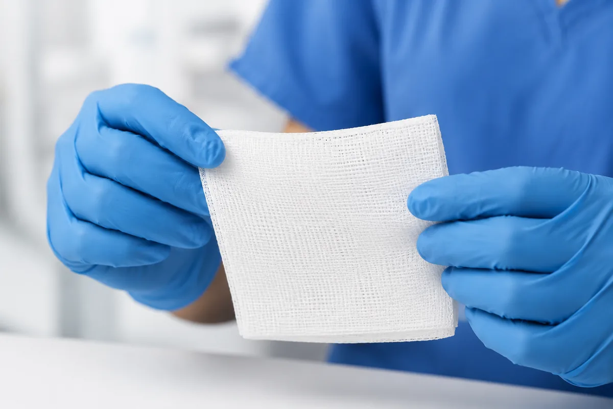 Profesional de la salud con guantes sosteniendo una Esponja de Gasa Suppler